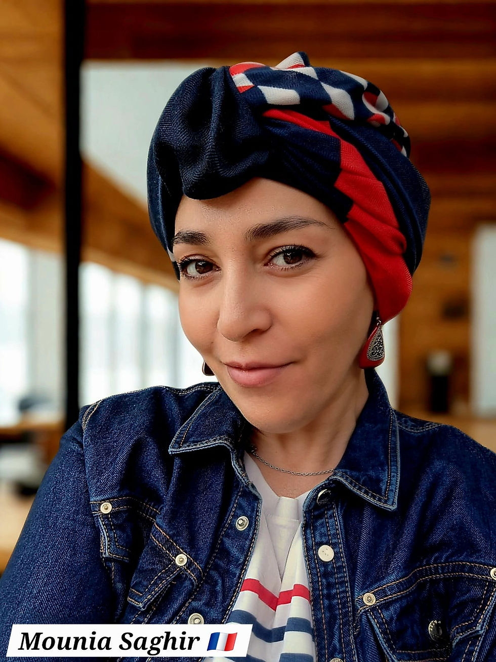 Woman in denim jacket and patterned headscarf, smiling indoors. Text: "Mounia Saghir" with French flag. Bright and warm setting.