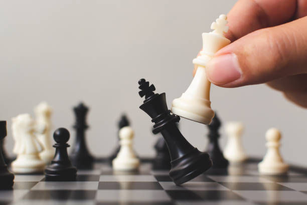 Hand of player chess board game putting white pawn