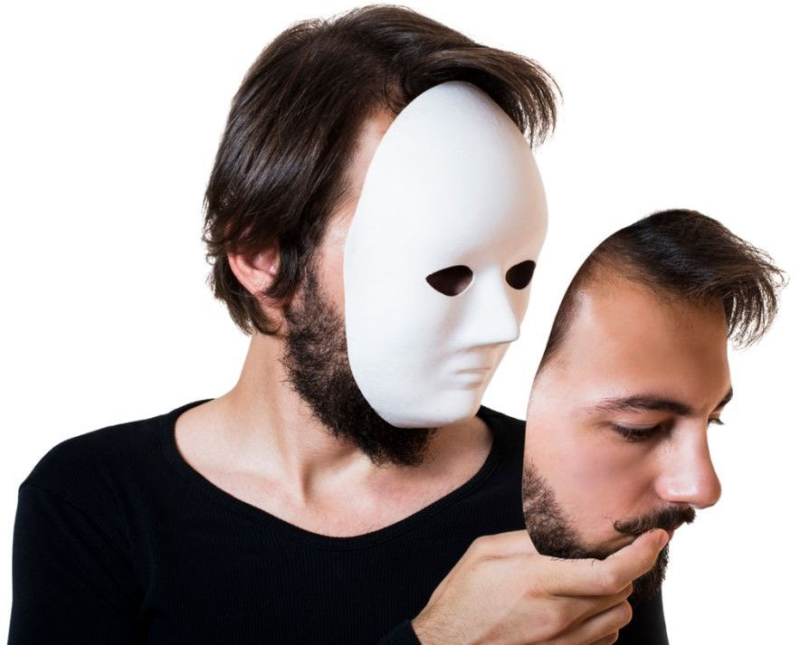 A man in a black shirt holds a mask to his face, with a lifelike face mask in his hand. Blank white background creates a surreal mood.