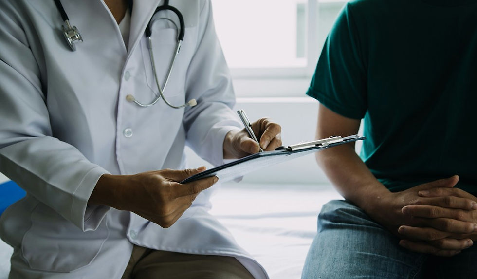 Doctor with stethoscope fills out a clipboard beside a seated patient in a bright clinic, calm and clinical.