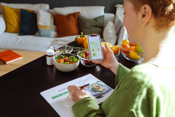  A woman is making a weekly nutrition plan and using mobile app