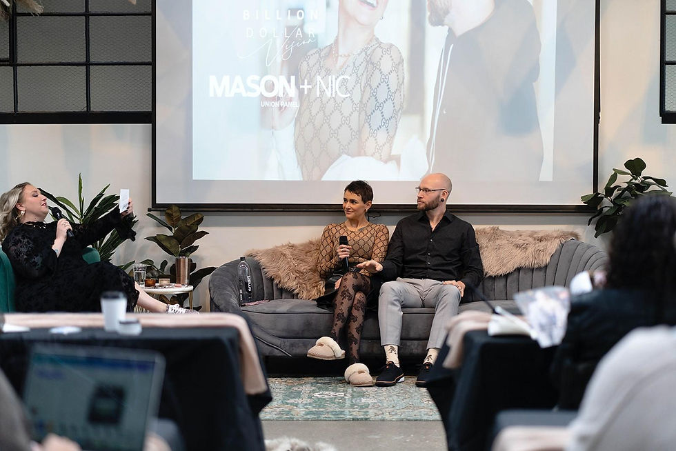 Panel discussion with a woman moderating and a man and woman sitting on a couch. "MASON + NIC" displayed on a screen behind them. Cozy setting.