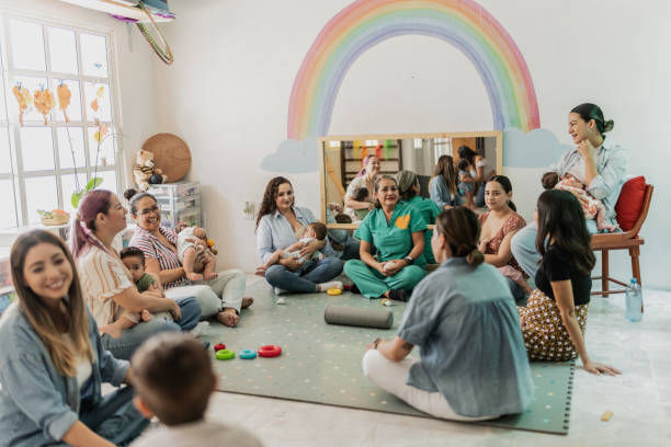Mature woman teaching mothers how to breastfeed their babies at the support group.
