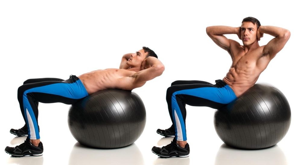 Two men in blue leggings doing sit-ups on black exercise balls. White background, focused and fit, demonstrating workout posture.