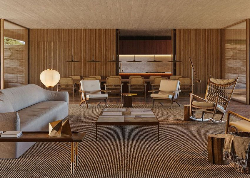 Stylish living room with beige sofa, wooden chairs, and a central table on a patterned rug. Warm lighting and wood-paneled walls create a cozy feel.