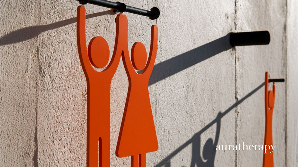 Orange male and female restroom signs hanging on a textured wall, with auratherapy text at bottom right.