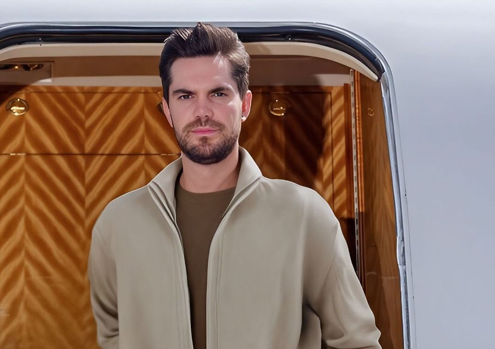 Man standing at a private jet entrance, wearing a beige jacket. The interior features wood paneling. He appears content and confident.