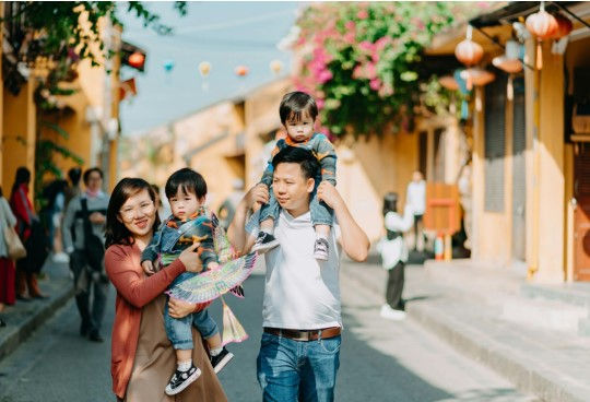 a family of four walking in the street on a sunny day