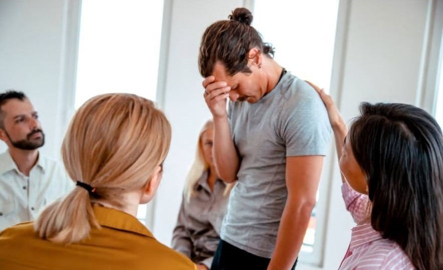 Sad and depressed man in a group therapy