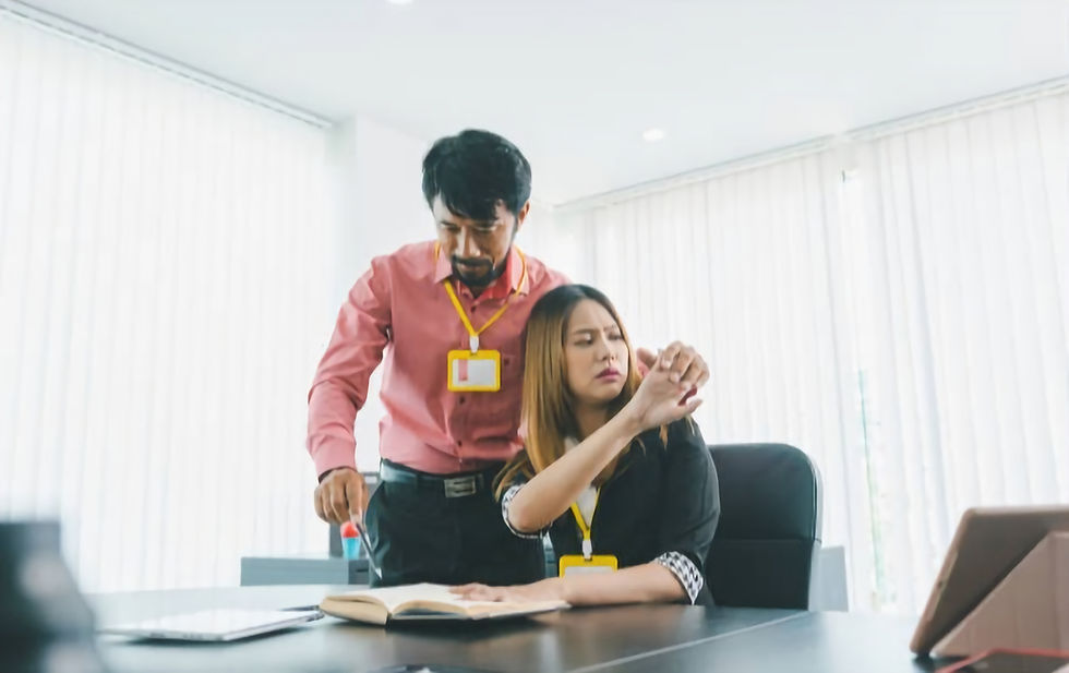 A male supervisor touching female employee's shoulder