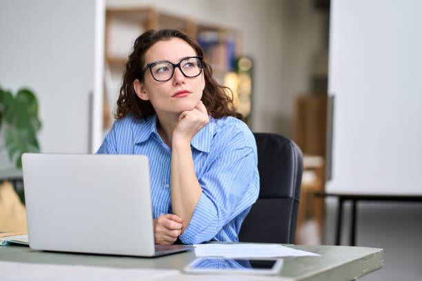  a woman in front of a laptop thinking