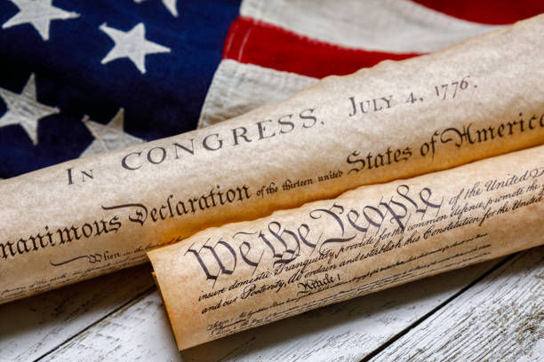 Two parchment scrolls with the Declaration of Independence on a U.S. flag, showing patriotic red, white, and blue colors.