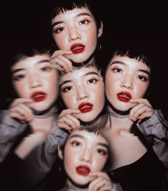 The image shows a stylized, artistic self-portrait of a young woman with dark hair and red lipstick, replicated and overlaid multiple times with motion blur.