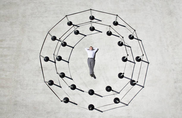 Businessman laying in circle of cordon posts