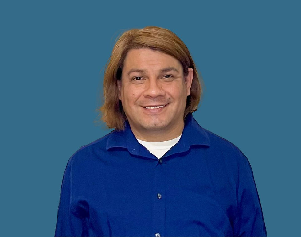 Smiling person with medium-length hair in a blue shirt against a plain blue background.