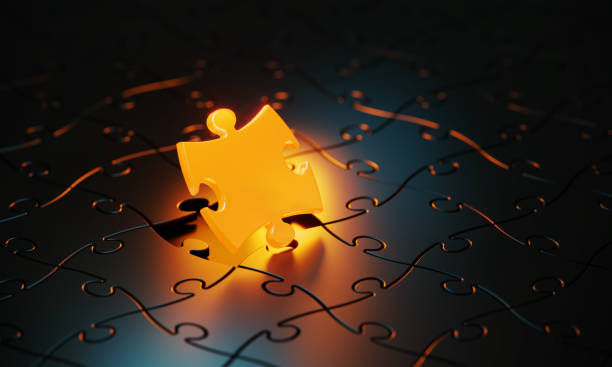 Orange jigsaw puzzle piece glowing on black background.