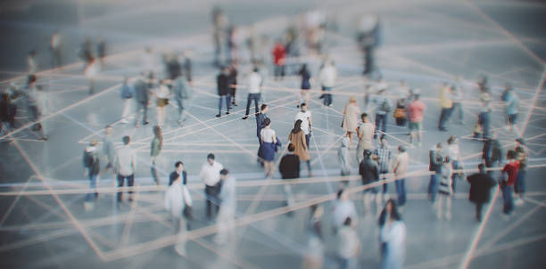 Aerial view of a crowd of people on a gray surface with intersecting lines, creating an abstract, organized pattern.