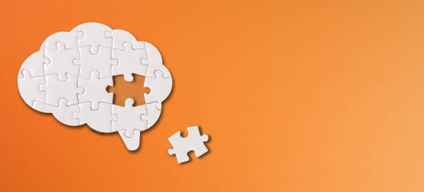 Brain shaped white jigsaw puzzle with copy space on orange background