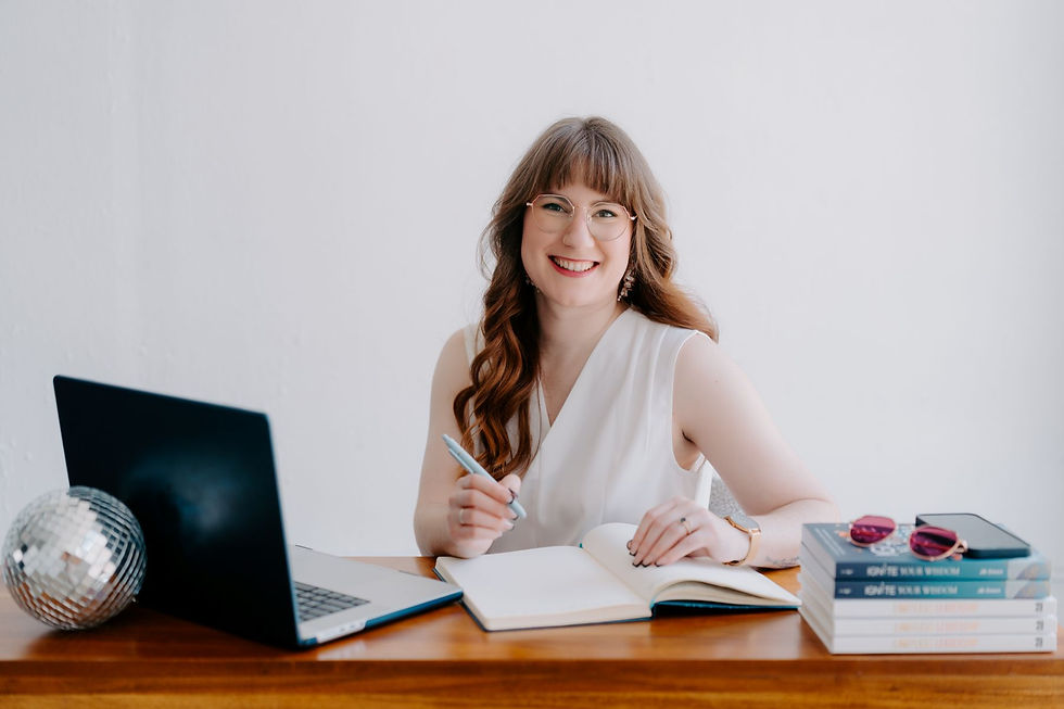 Smiling woman in white, writing in a notebook at a desk with a laptop and stacked books titled "Ignite Your Wisdom." A disco ball and sunglasses add flair.