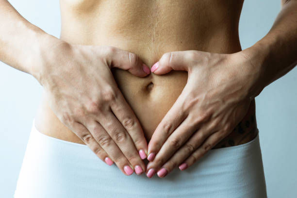 Belly of an unrecognizable slim caucasian woman wearing white sportswear