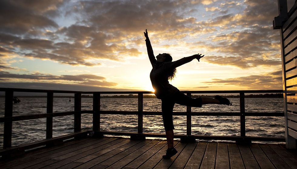 A person is captured in silhouette performing a joyful