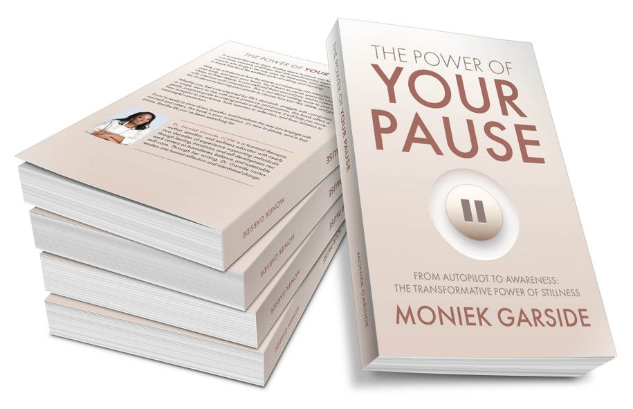 Stack of beige books titled The Power of Your Pause by Moniek Garside, with a pause icon on the cover, on a white background.