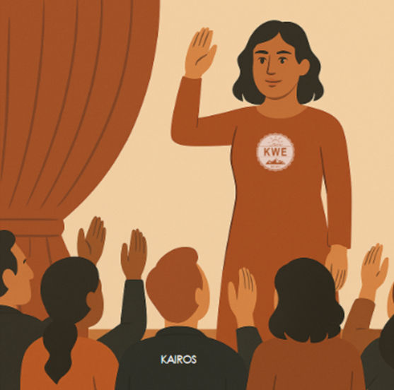 Woman in orange dress with "KWE" logo raises hand on stage, facing audience. Audience members raise hands. Mood: formal.