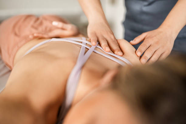 A person is receiving a therapeutic back massage, with hands gently applying pressure on their upper back and shoulder area.