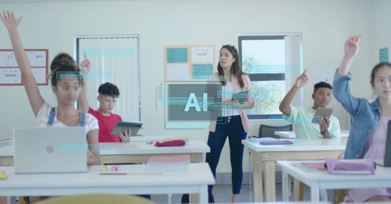 Students in a classroom raise hands while a teacher stands near a board displaying "AI." Tablets, laptops, and papers are on desks. Bright setting.