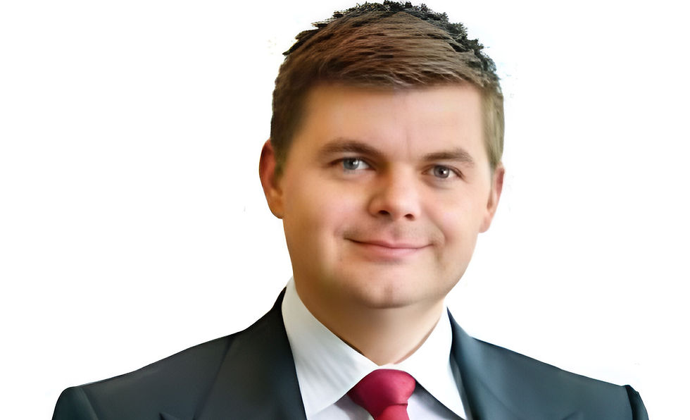 Smiling man in a suit with a red tie on a white background, conveying a professional and pleasant mood.
