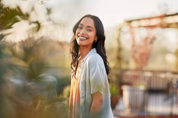 Young latin woman in casual clothing in the garden looking at camera
