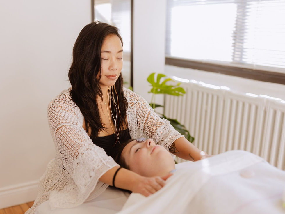 Woman giving a facial massage to a relaxed client in a bright room with white blinds and a green plant. Calm and serene atmosphere.