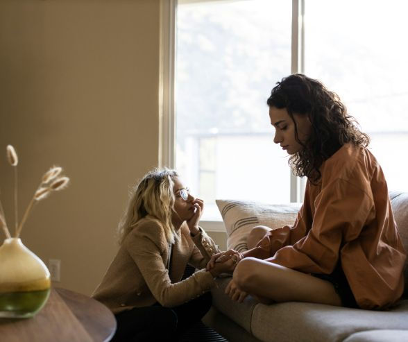 two sad women on a living room