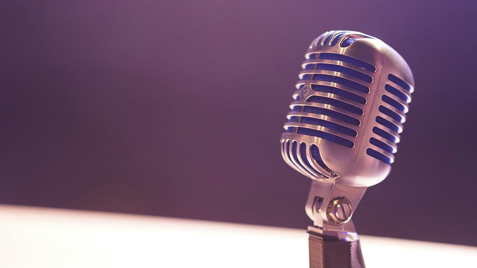 A vintage silver microphone on a stand against a purple backdrop, casting a classic and nostalgic mood.