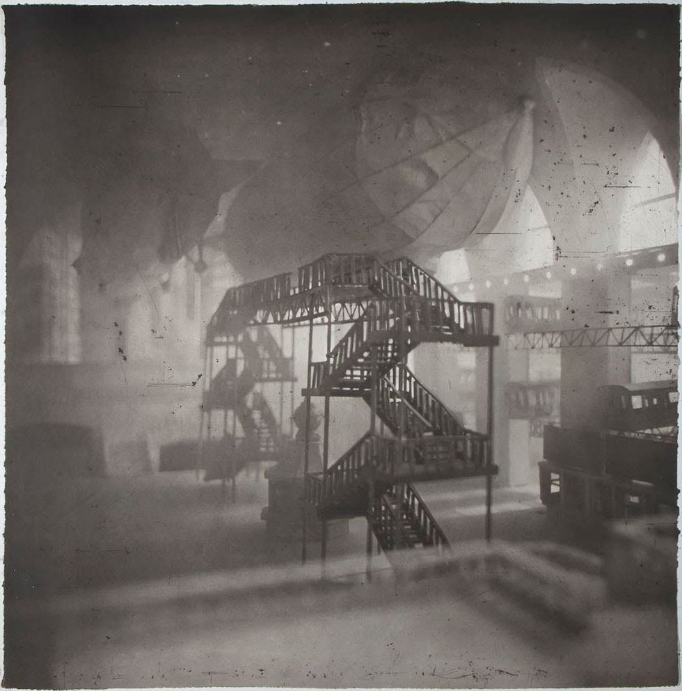 Grayscale architectural model with a central spiral staircase and bridges in a hazy industrial room.