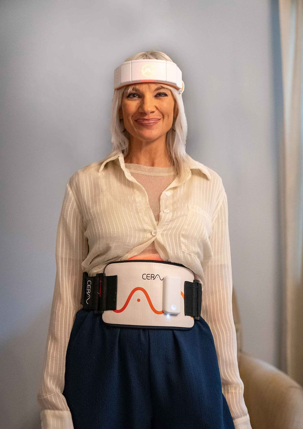 A woman smiles while wearing a white headband and a device labeled "CERA" around her waist. Background is a neutral room.