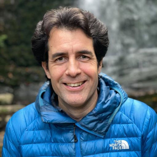 man in blue jacket smiling at camera