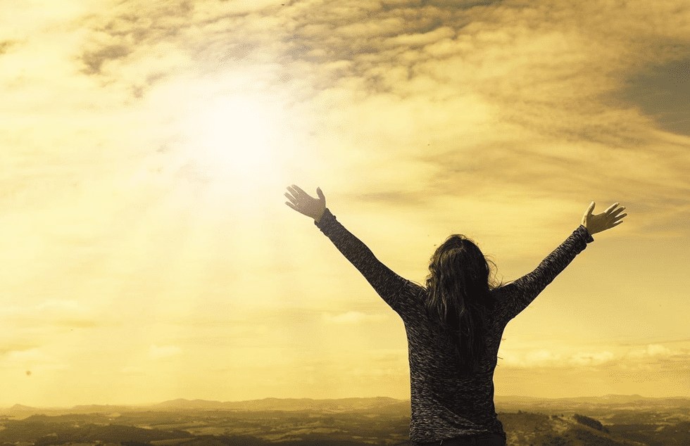 Woman rejoicing during sunset