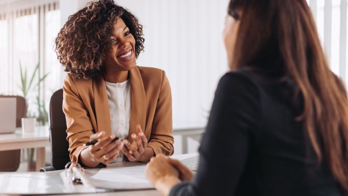 two happy women talking inside the office