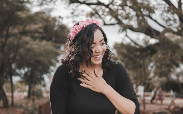 A happy woman in black long sleeve dress