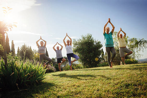 Small group of senior in a yoga class outdoors on a sunny da