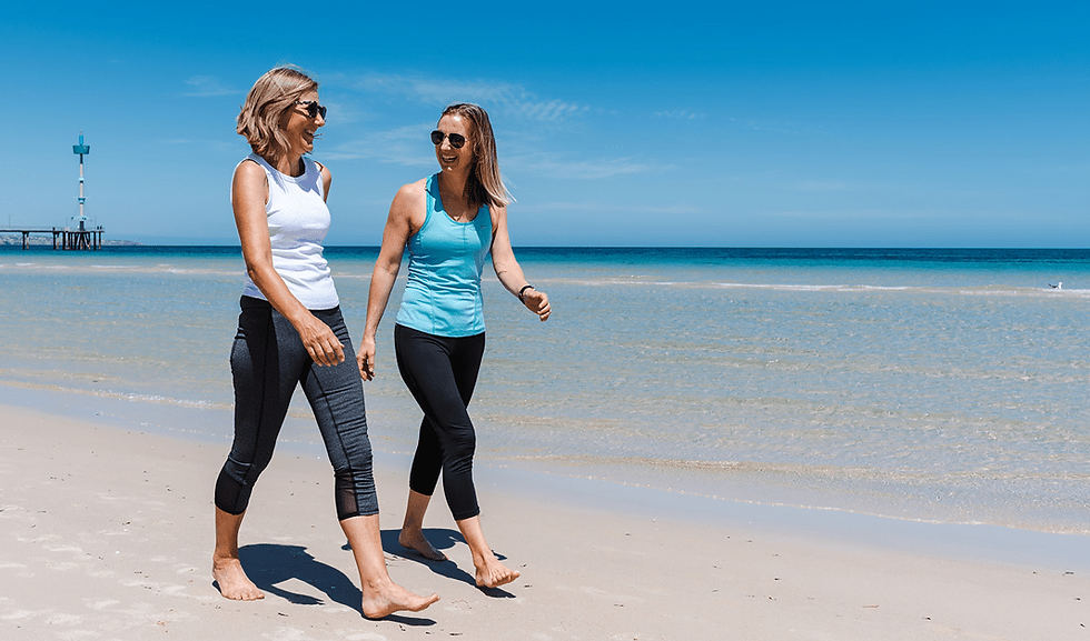 Photo of two happy people walking at the beach.