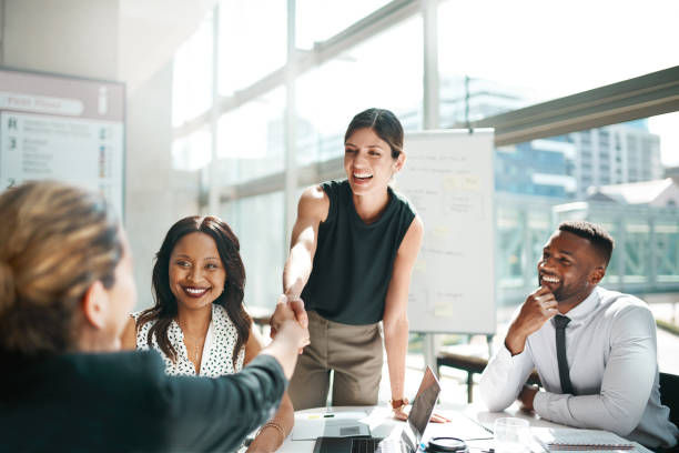 Shot of colleagues shaking hands in a meeting