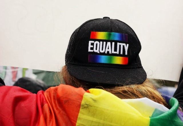 Person wearing black Equality printed cap