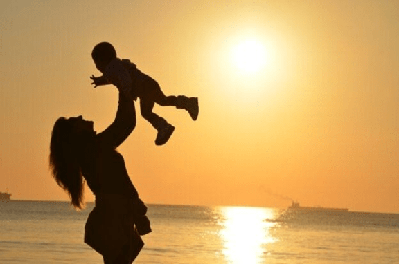 Silhouette of woman and a baby during sunset