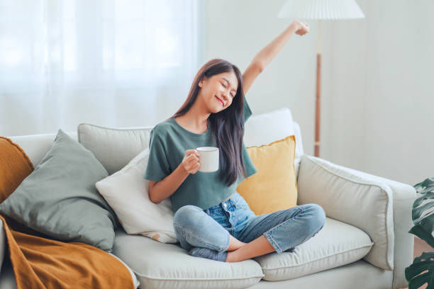 Smiling female enjoying resting sitting on couch in modern living room.