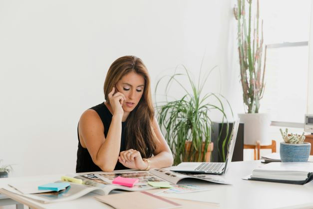 Woman talking to smart phone while working at home
