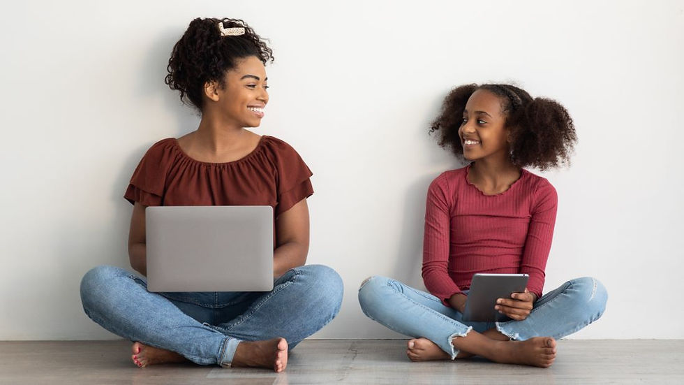 Mom and daughter sitting on floor while using laptop and a tablet