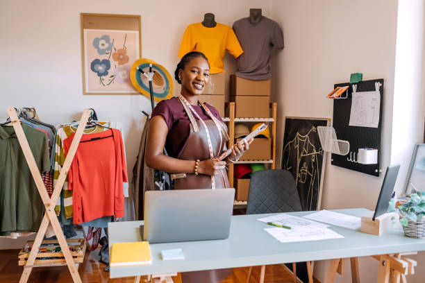 Portrait of young woman starting new business opening tailor shop.