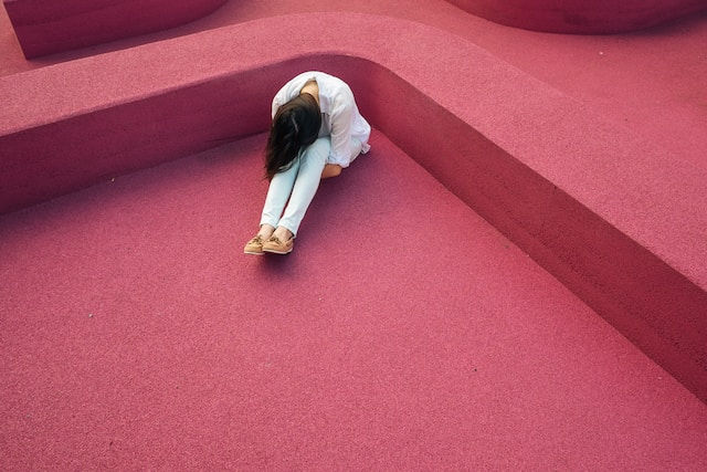 A sad woman in pink background.